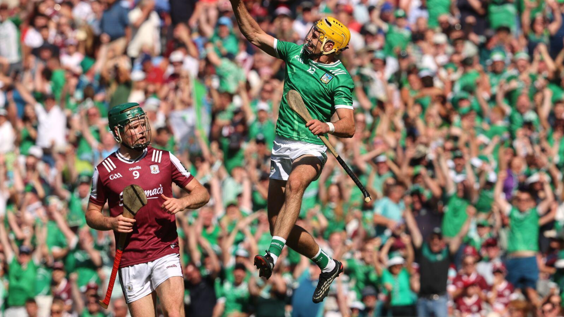 Limerick hurler in green leaping in celebration in front of the crowd at Croke Park